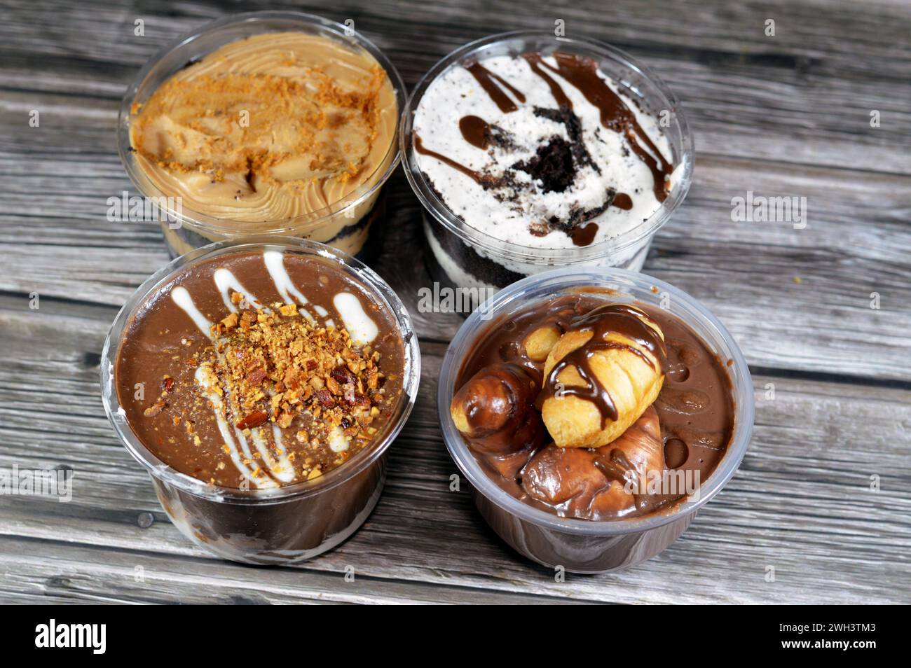 Gemischte cremige Schokoladen-Profiteroles, mit Mini-Croissant gefüllt mit Schokolade, Soße, Erdnussbutter, Mandeln und cremigem Biscuit-Mousse mit Schokolade Stockfoto