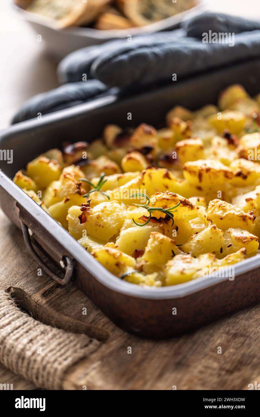 Gebackene knusprige Kartoffeln mit Rosmarin in einer alten Auflaufform. Stockfoto