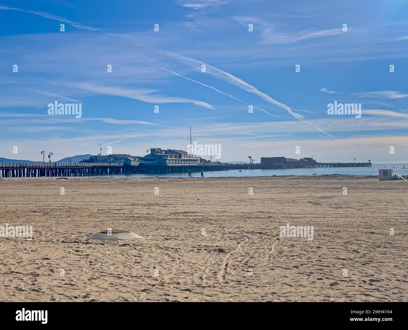 Santa Barbara, CA, USA - 28. Januar 2024: Stearns Wharf Pier mit Harbor Restaurant oben. Weite Landschaft mit West Beach vorne, unter blauer Wolke Stockfoto