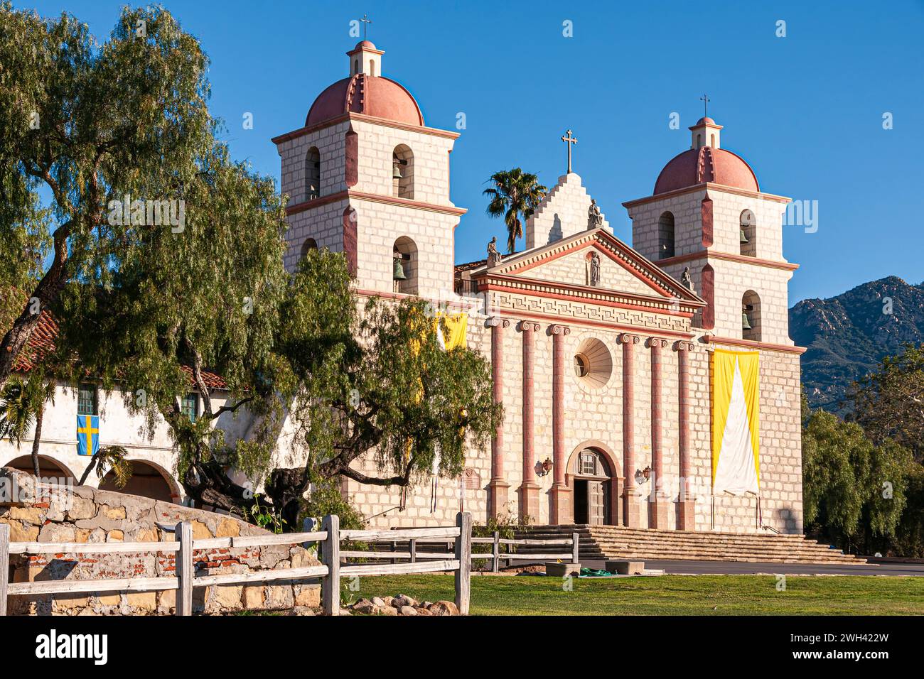 Santa Barbara, CA, USA - 20. April 2009: Fassade der alten Mission Kirche in der Sonne mit Baum unter blauem Himmel. Stockfoto