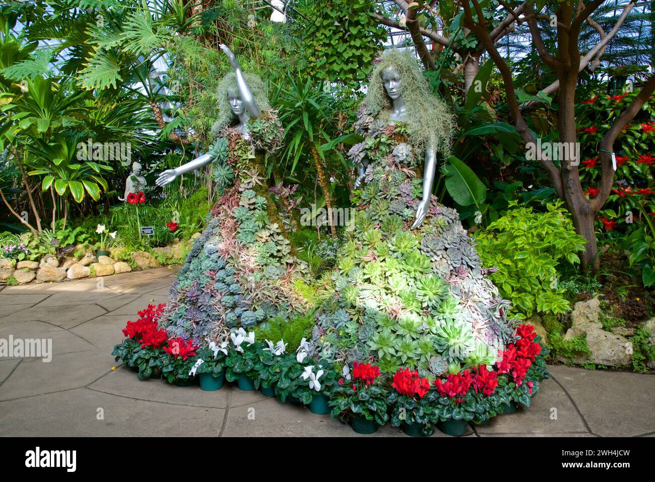 Ausstellung der mit Pflanzen und Blumen bedeckten Schaufensterpuppen im Wintergarten Stockfoto