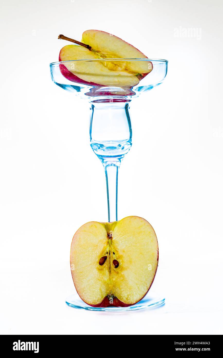 Zwei Hälften eines leckeren Apfels in einer Komposition aus Glas. Essen Sie Äpfel für die Gesundheit. Stockfoto Zwei Hälften eines leckeren Apfels in einer Komposition aus Glas. Essen Sie Äpfel für die Gesundheit. Stockfoto