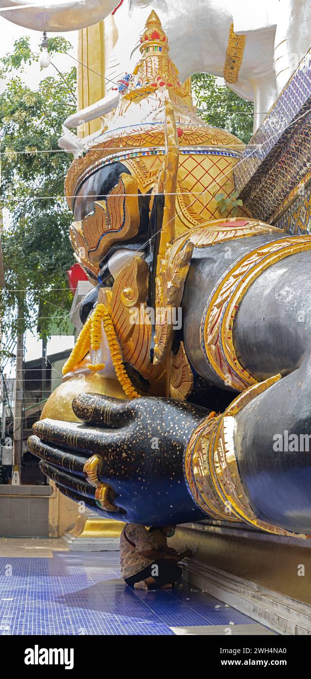 Die mythologische Figur Phra Rahu im buddhistischen Tempel mit Gläubigen unter seinen Händen, Thailand Stockfoto