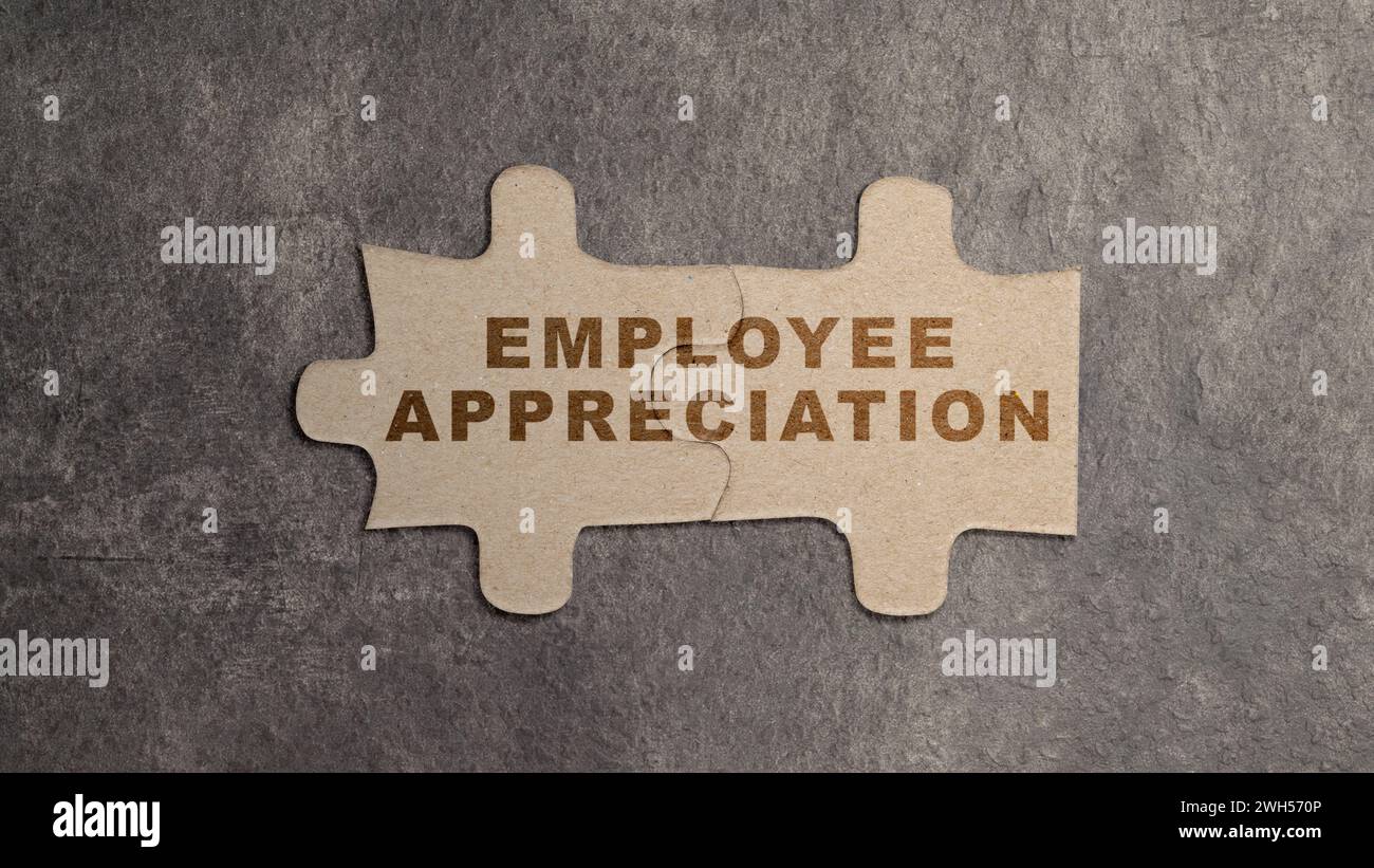 Zwei Puzzleteile mit Text „Mitarbeiterwertschätzung“ auf schwarzem Hintergrund. Wertschätzungskonzept Stockfoto