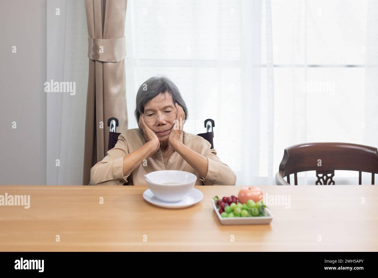 Einsame ältere asiatische Frau, gelangweilt vom Essen. Stockfoto