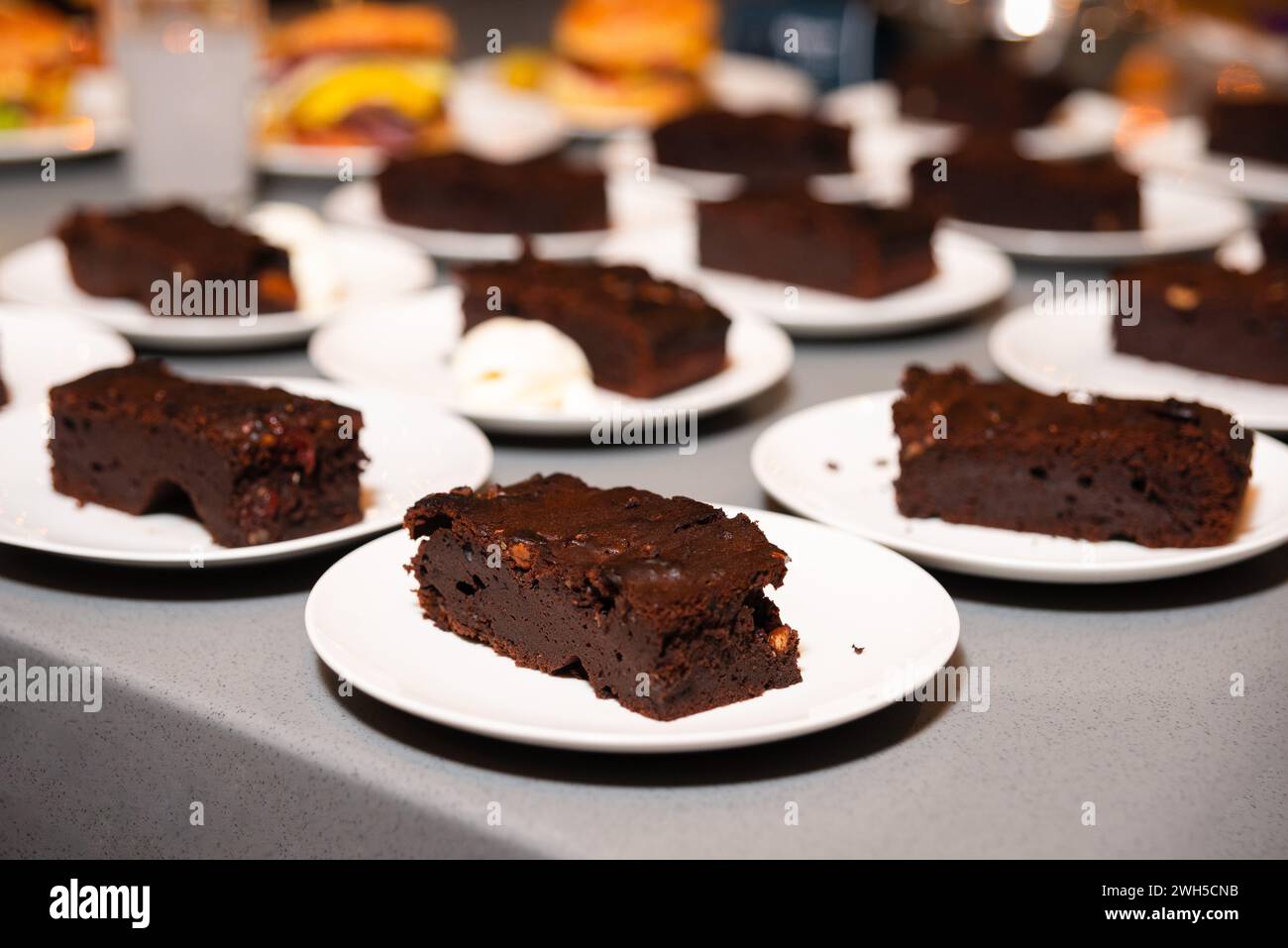 Teller mit dicken und fudgy Schokoladen Brownies, begleitet von einem Klecks Schlagsahne, bereit für den Dessert-Service. Stockfoto