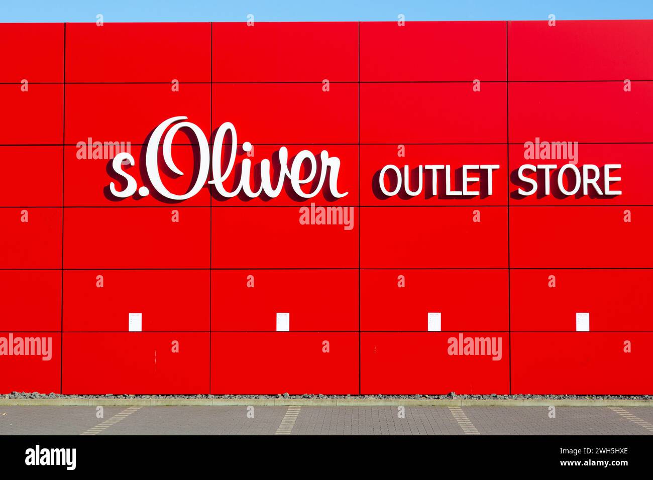 Mulheim-Karlich, Deutschland - 27. Februar 2021:: Rote Fassade des Outlet Stores s.Oliver. s.Oliver ist ein deutsches Modeunternehmen, das Kleidung, Schuhe und Schuhe verkauft Stockfoto