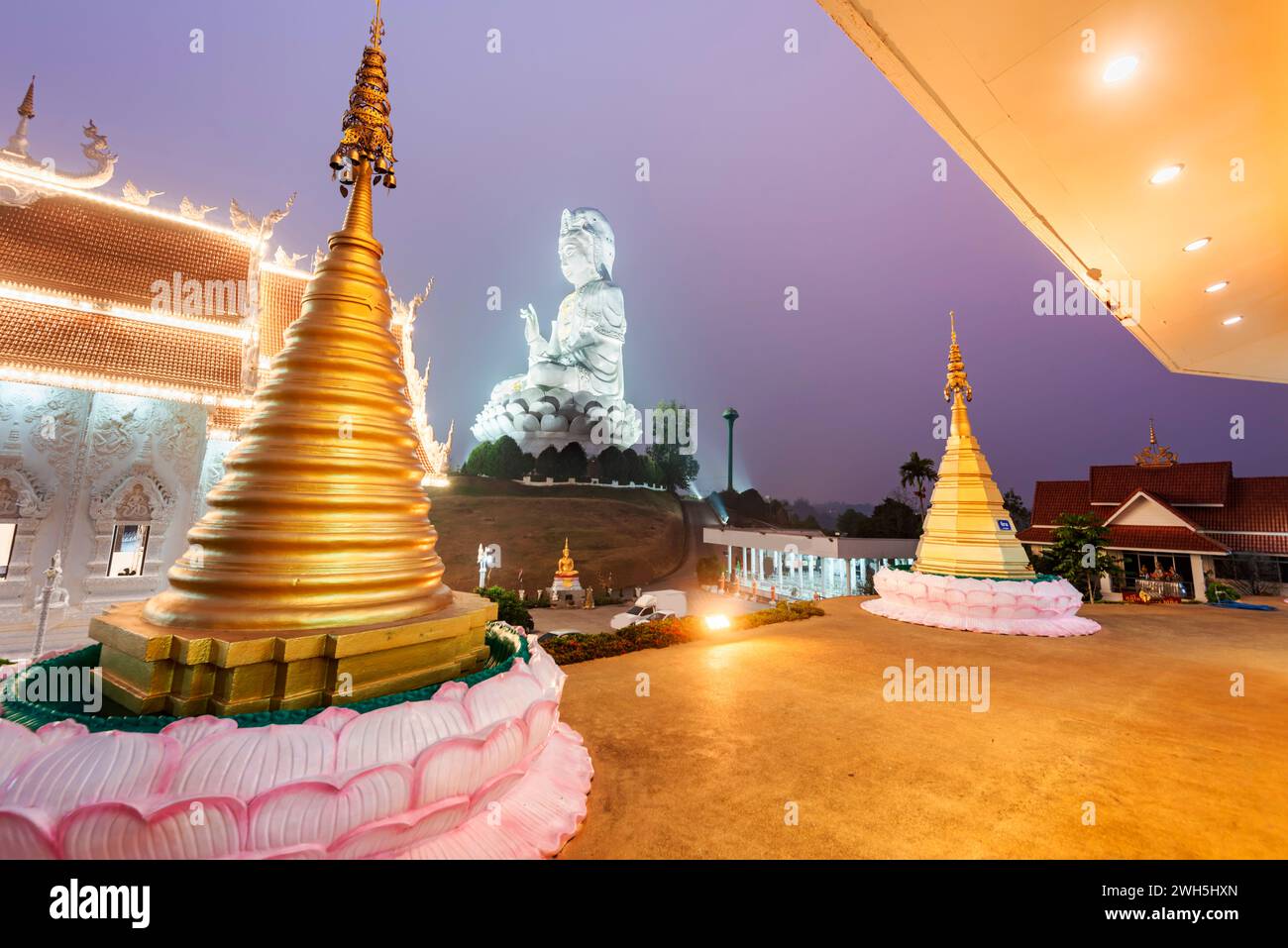 In der Abenddämmerung beleuchtet, ist die Architektur herrlich mit der Mischung aus chinesischer Guan Yin Statue, Drachentreppen, weißem MarmorBuddha und Thaj-Architektur.B Stockfoto