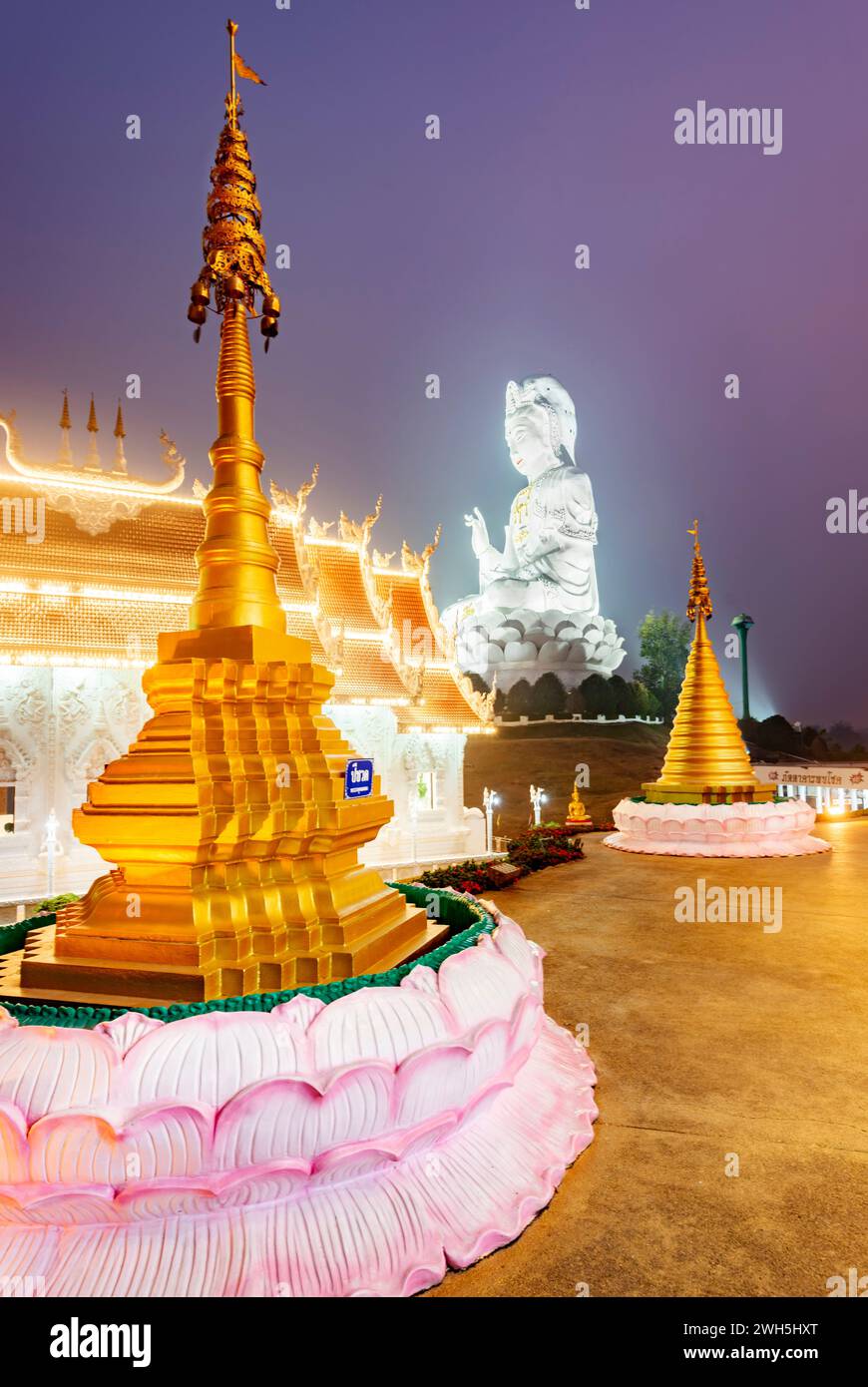 In der Abenddämmerung beleuchtet, ist die Architektur herrlich mit der Mischung aus chinesischer Guan Yin Statue, Drachentreppen, weißem MarmorBuddha und Thaj-Architektur.B Stockfoto