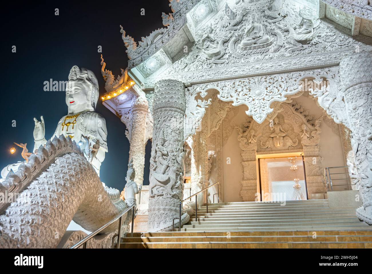 In der Abenddämmerung beleuchtet, ist die Architektur herrlich mit der Mischung aus chinesischer Guan Yin Statue, Drachentreppen, weißem MarmorBuddha und Thaj-Architektur.B Stockfoto
