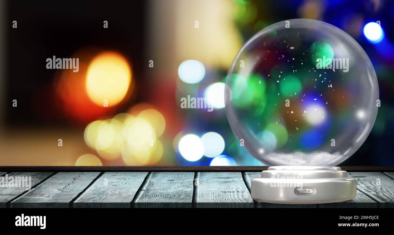 Bild einer weihnachtsschneekugel mit weihnachtsfeenlichtern im Hintergrund Stockfoto