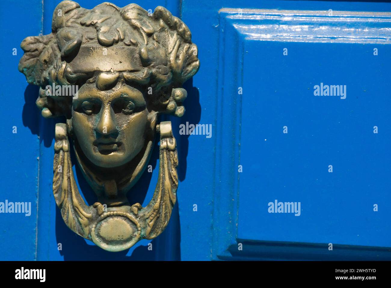 Eine kleine Statue neben einer blauen Tür. Stockfoto