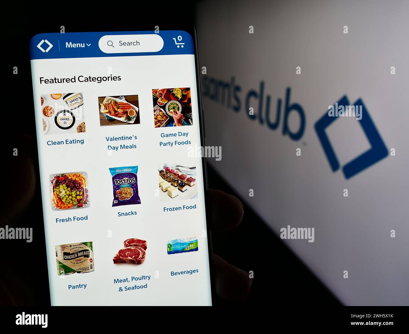 Person, die ein Mobiltelefon hält, mit der Webseite des Einzelhandelsunternehmens Sam's Club, das nur für US-Mitglieder gilt, vor dem Logo. Konzentrieren Sie sich auf die Mitte des Telefondisplays. Stockfoto