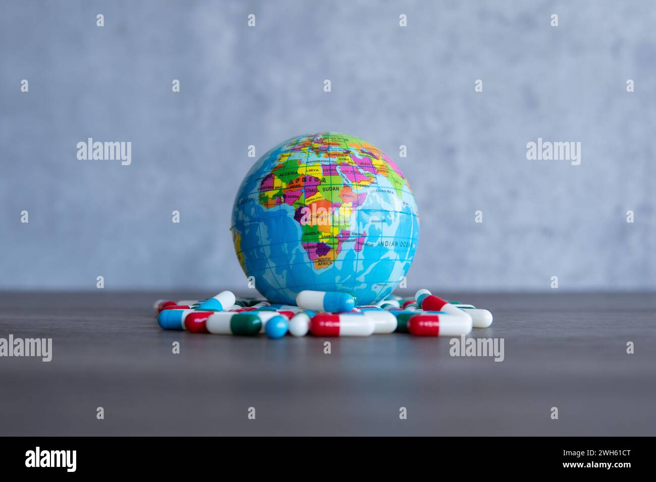 Farbenfroher Haufen von Medikamententabletten und Globus. Kopierbereich für Text. Medizin- und Gesundheitskonzept. Stockfoto