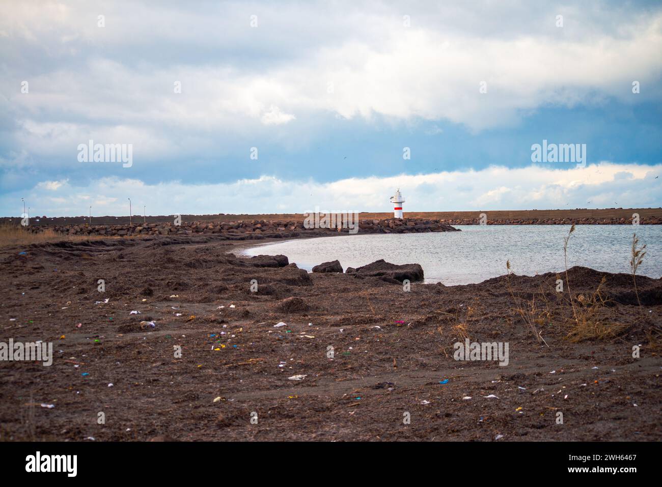 Eine fesselnde Küstenszene mit einem Leuchtturm, der stolz am Meer steht und als Navigationspunkt entlang der Küste des Ozeans dient Stockfoto