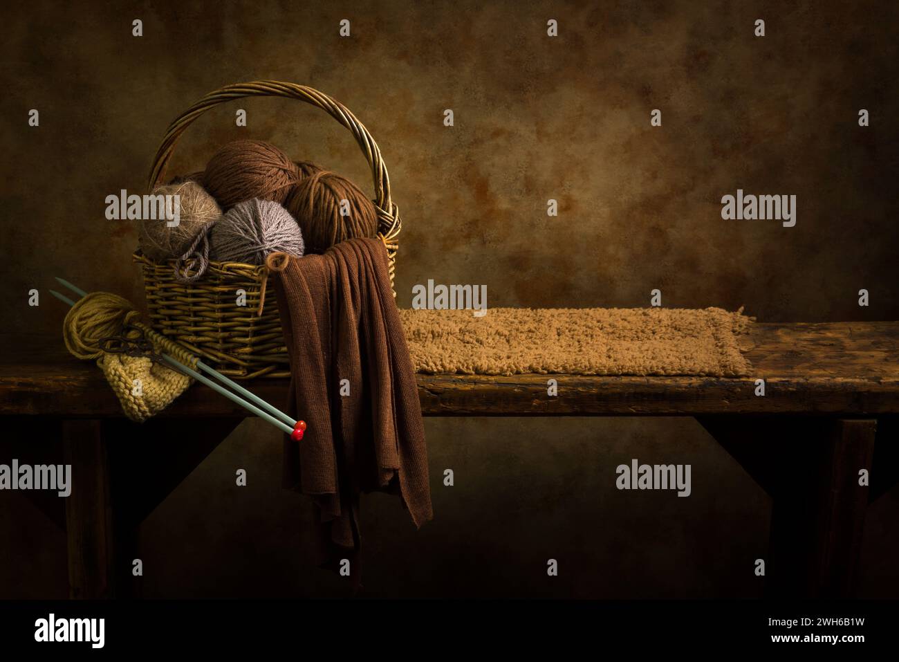 Korb mit braunen Wollkugeln auf einem rustikalen alten Holzregal. Dies ist für das digitale Compositing geeignet. Stockfoto