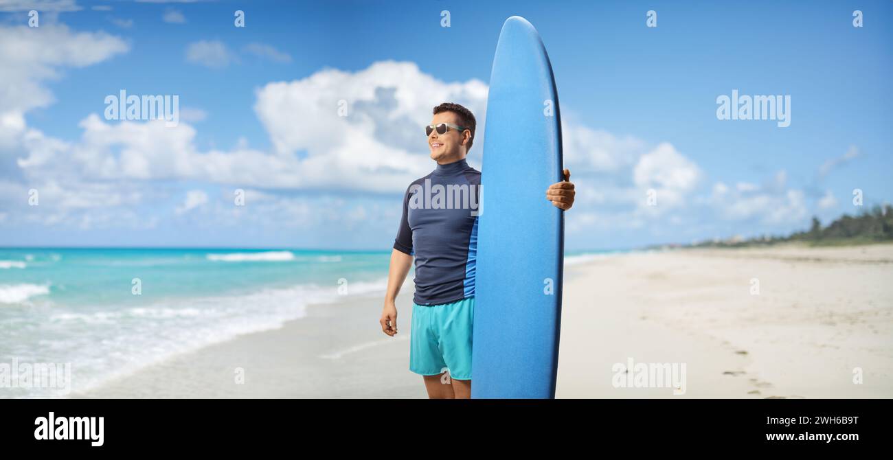 Ein Mann mit einem Surfbrett, der an einem Strand in Kuba, Varadero, steht Stockfoto