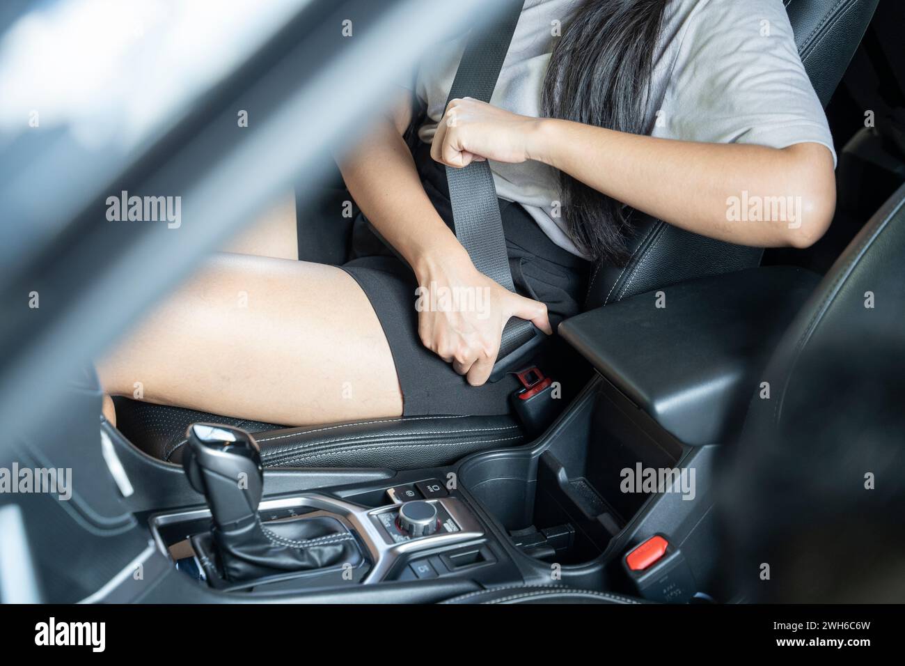 Nahaufnahme einer Handfrau, die im Auto den Sicherheitsgurt zieht; Konzept der Fahrzeugsicherheit. Stockfoto