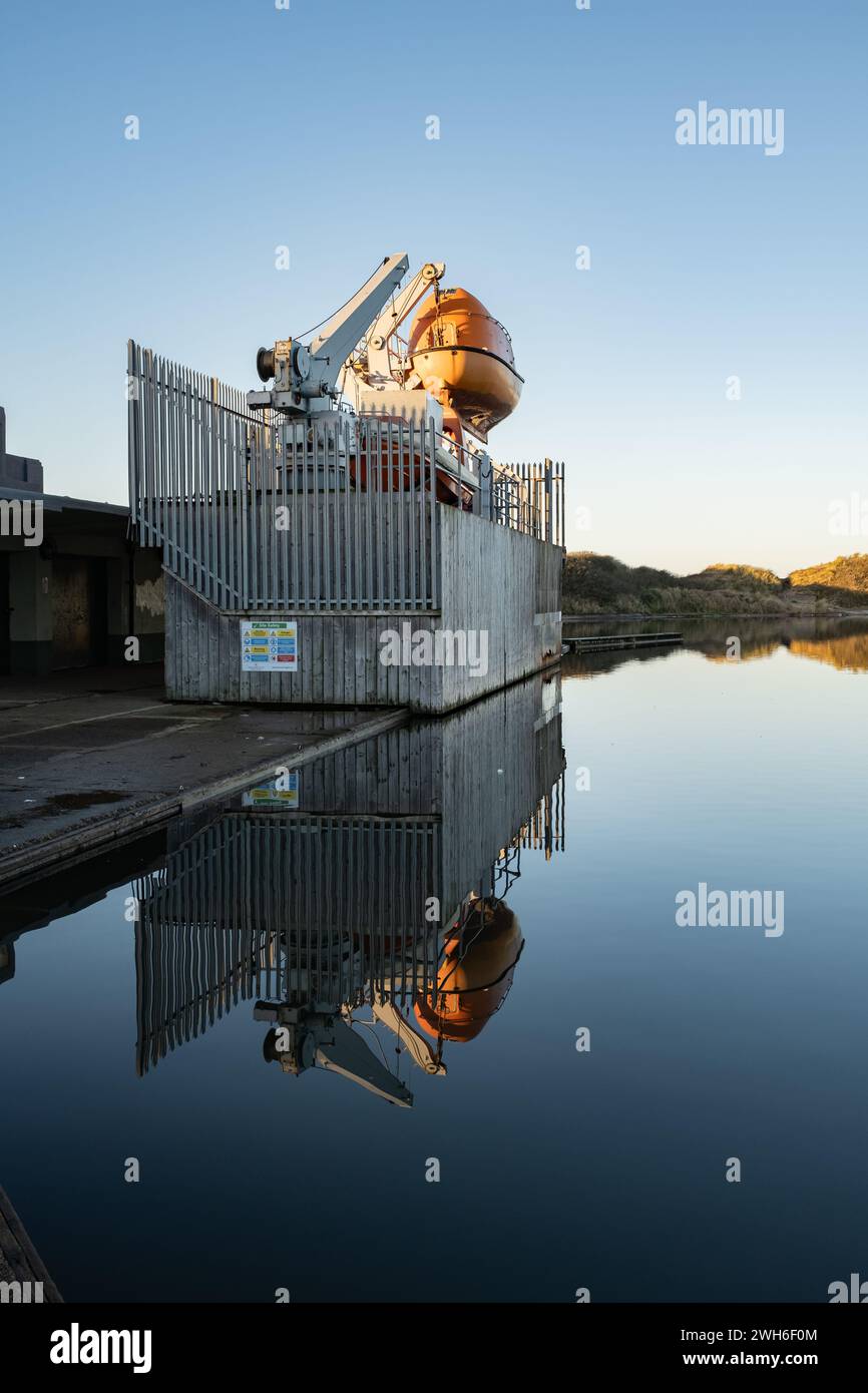 Fleetwood Lancashire Rettungsboot Trainingsbereich am Seeufer, orange geschwungenes Überlebensboot auf einem hydraulischen Hebezeug. Stockfoto