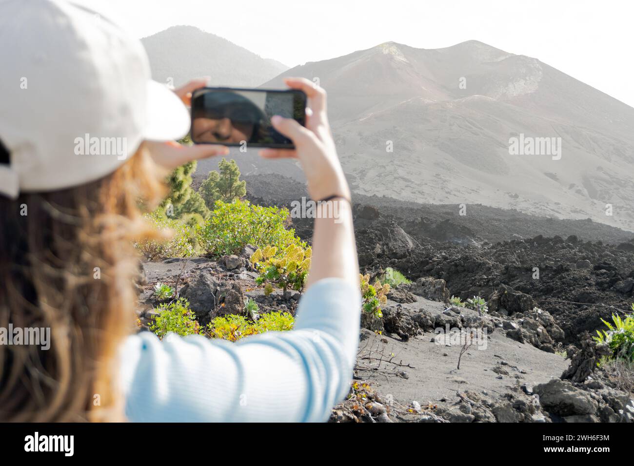 Frau, die mit Handy fotografiert und Reflexion sieht Stockfoto