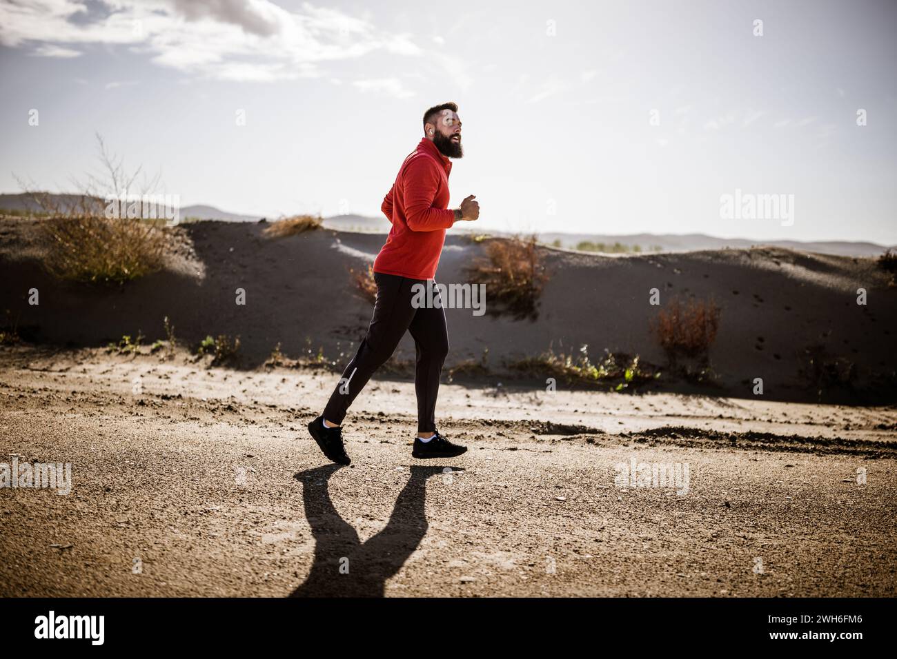 Erwachsener Mann joggt draußen an sonnigen Tagen. Stockfoto