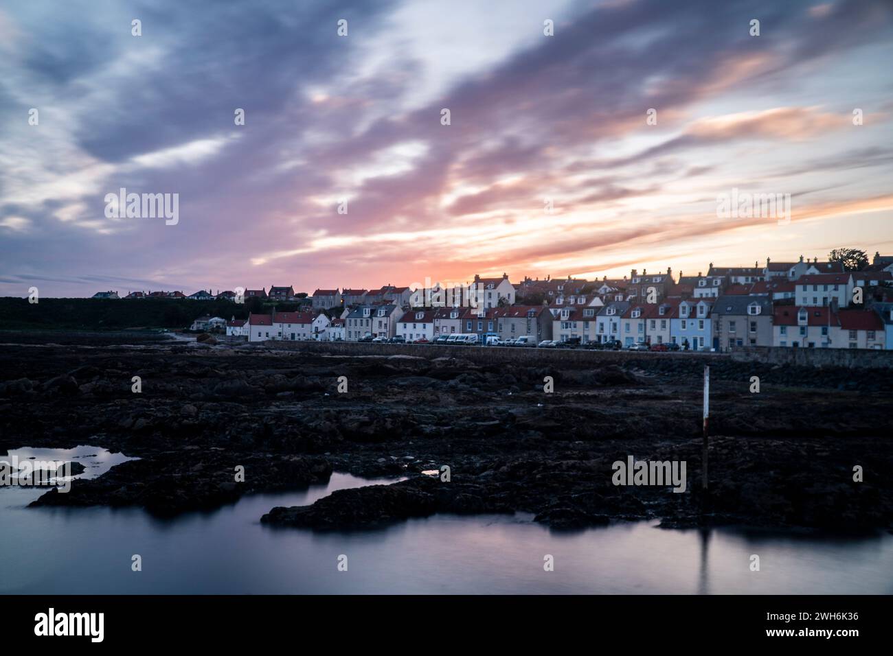 Der lebhafte Sonnenaufgang übermalt den Himmel über den charmanten Häusern Stockfoto