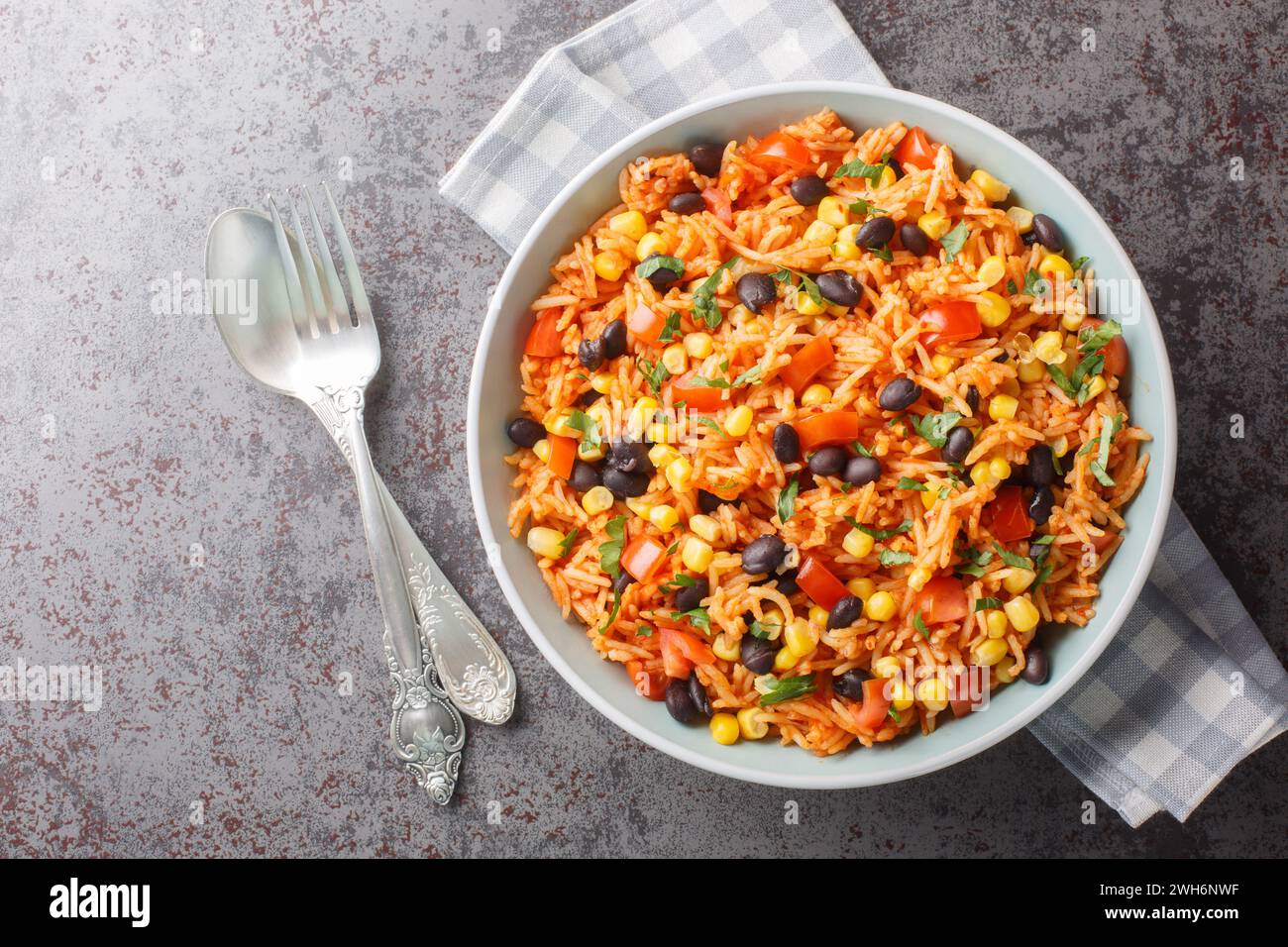 Spanischer, mexikanischer Tomatenreis mit Bohnen in einer Schüssel auf dem Tisch. Horizontale Draufsicht von oben Stockfoto