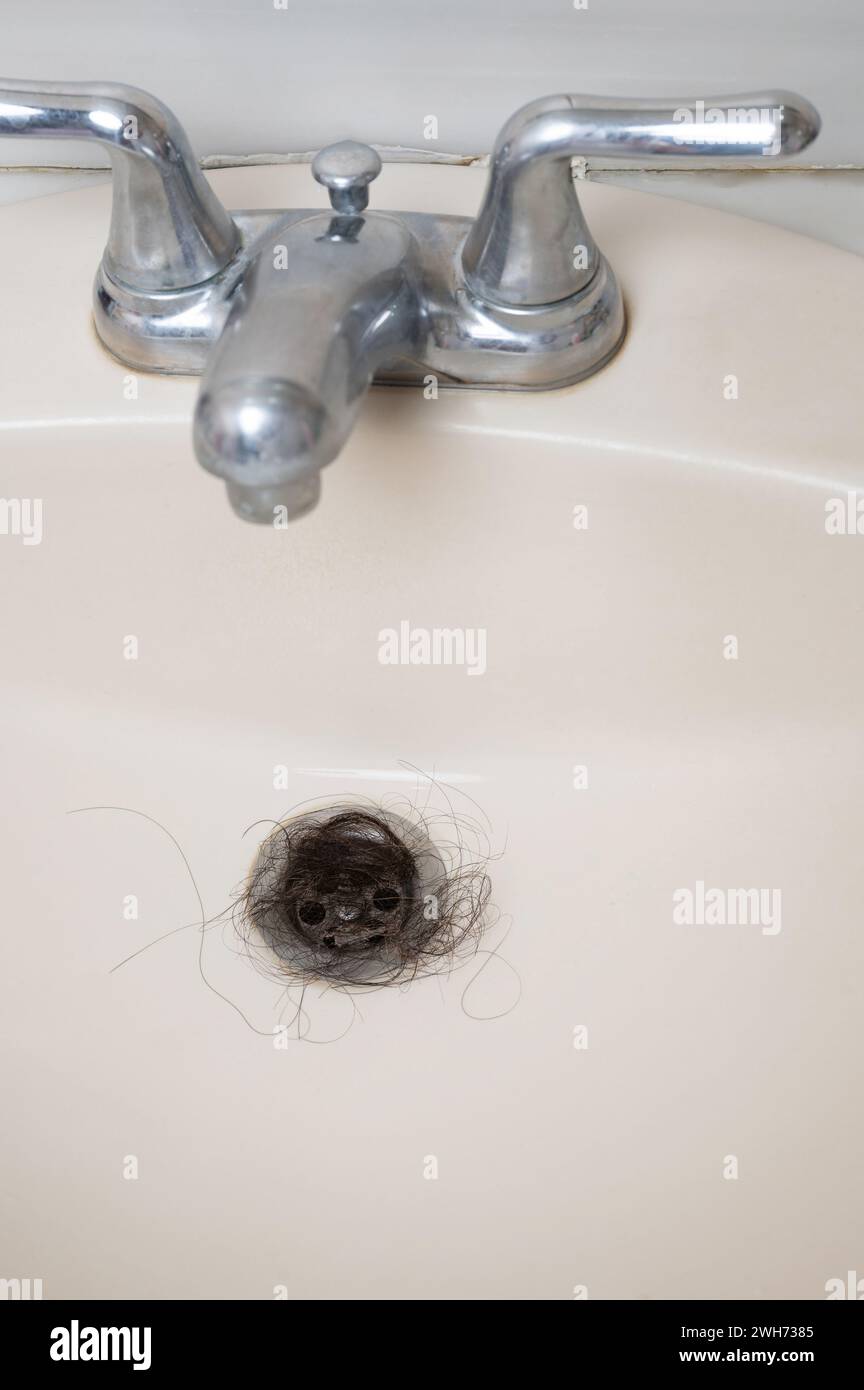 Verstopfte Abflussöffnung im Waschbecken mit Makroaufnahme dunkler Haare Stockfoto