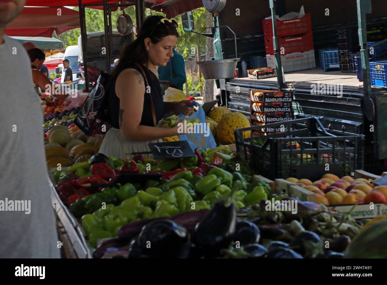 Frau, die Obst und Gemüse auf dem Markt Vouliagmeni Athen Attika, Griechenland, wählt Stockfoto