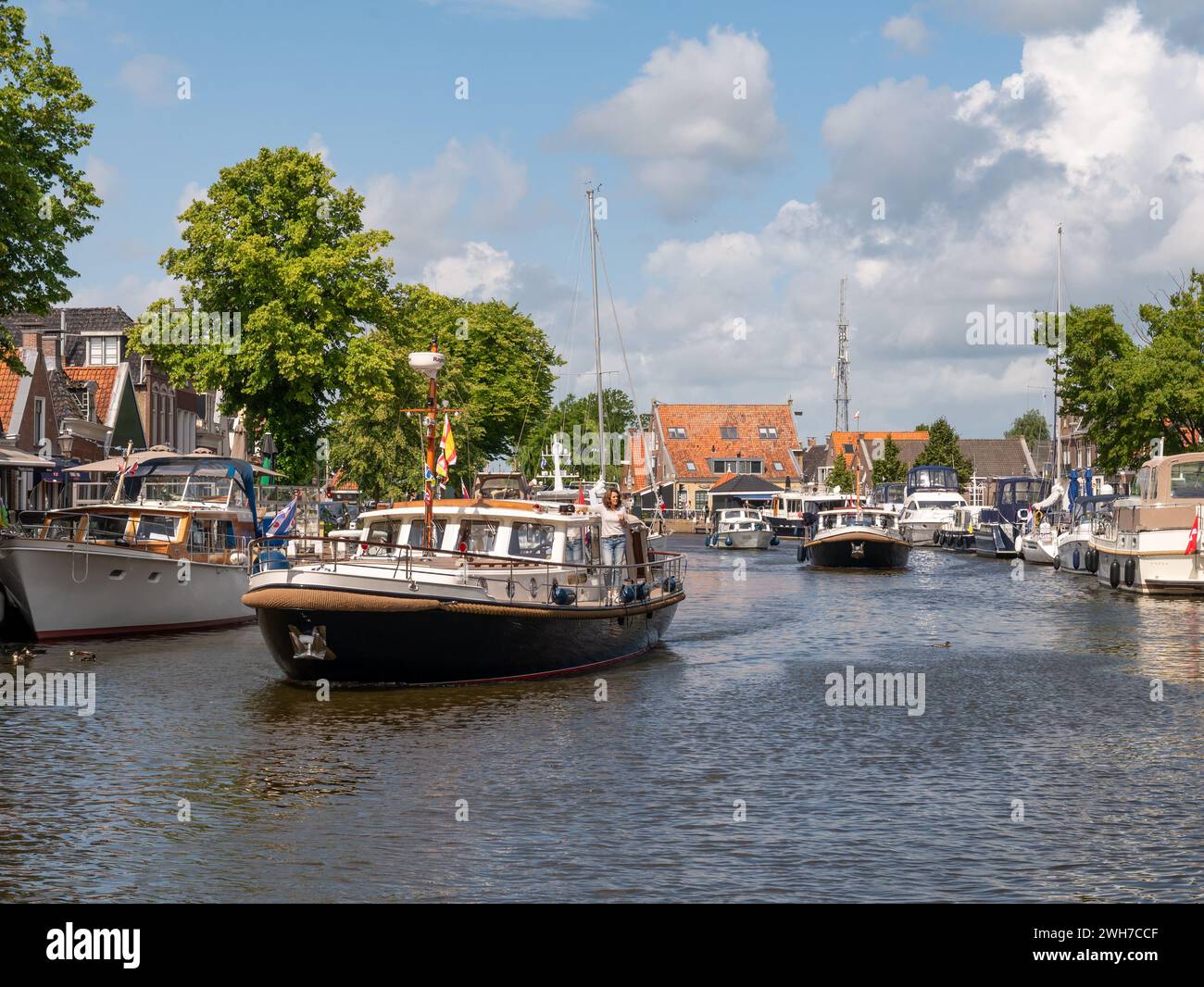 Motorboote auf der Suche nach Anlegestellen im Het Dok Kanal in der Altstadt von Lemmer, Friesland, Niederlande Stockfoto
