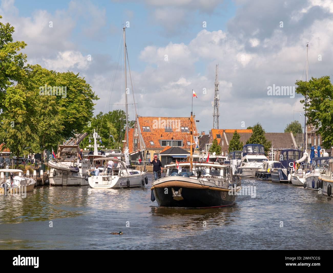 Boote auf der Suche nach Anlegestellen im Het Dok Kanal in der Altstadt von Lemmer, Friesland, Niederlande Stockfoto