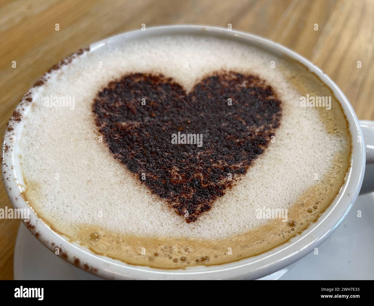 Von oben gesehen eine Tasse Kaffee mit einem Liebesherz aus Schokoladenstreuseln. Romatic. Valentinstag Stockfoto