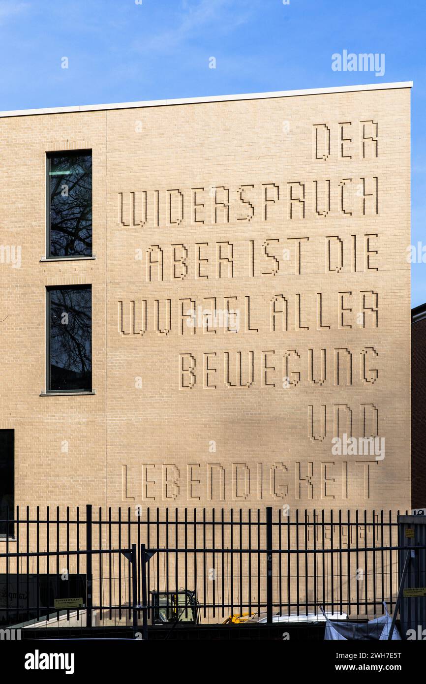 Neuausbau des Hansa-Gymnasiums am Gereonswall, Zitat von Georg Wilhelm Friedrich Hegel an der Fassade, Übersetzung: Widerspruch ist die Wurzel eines Stockfoto