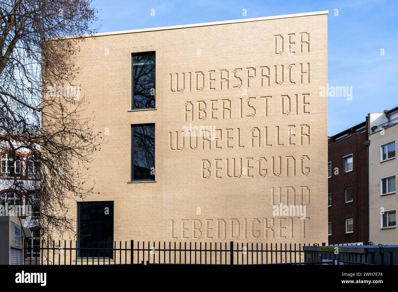Neuausbau des Hansa-Gymnasiums am Gereonswall, Zitat von Georg Wilhelm Friedrich Hegel an der Fassade, Übersetzung: Widerspruch ist die Wurzel eines Stockfoto