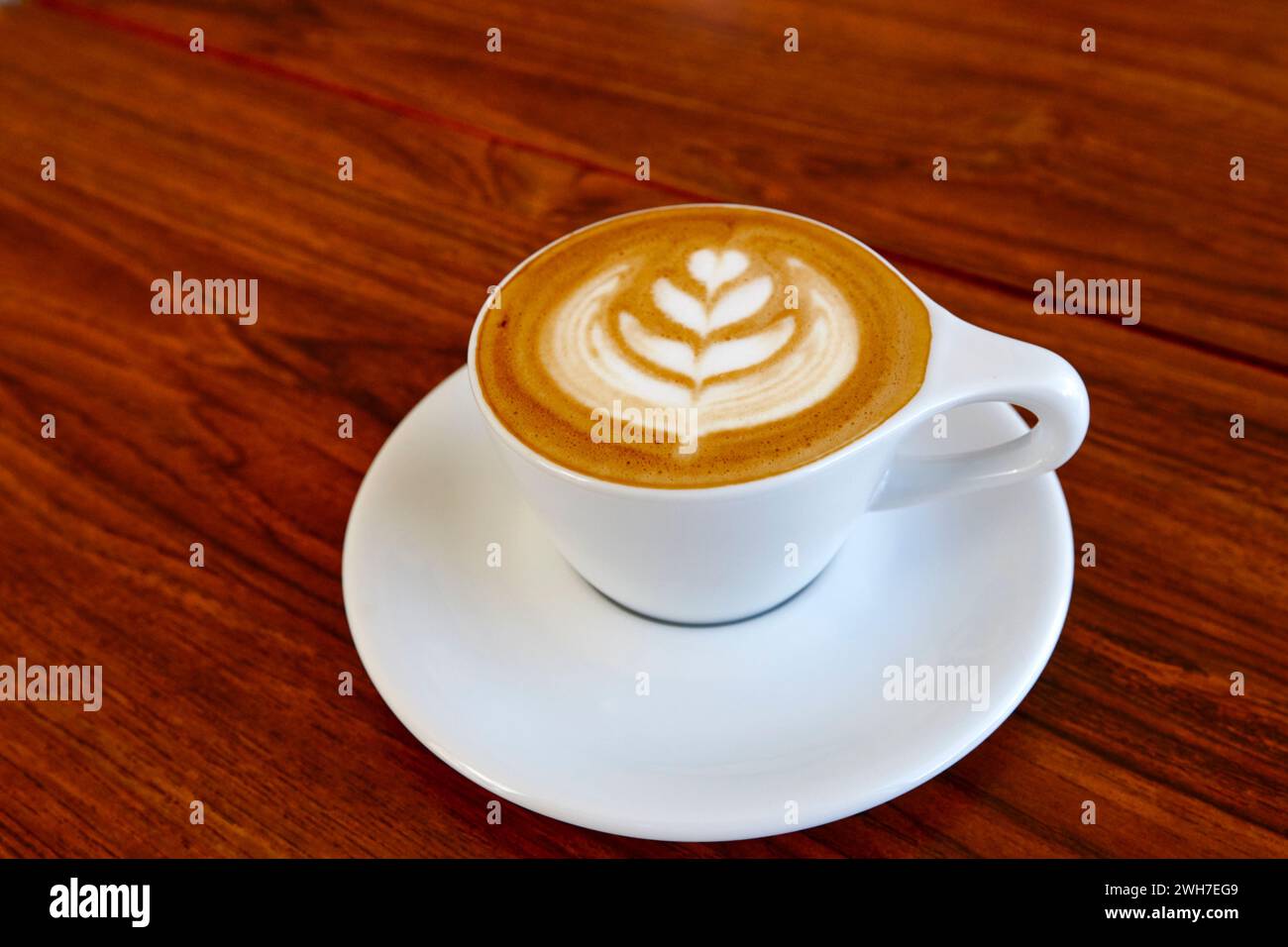 Tasse Kaffee in einer weißen Tasse und Untertasse auf einem Holztisch Stockfoto