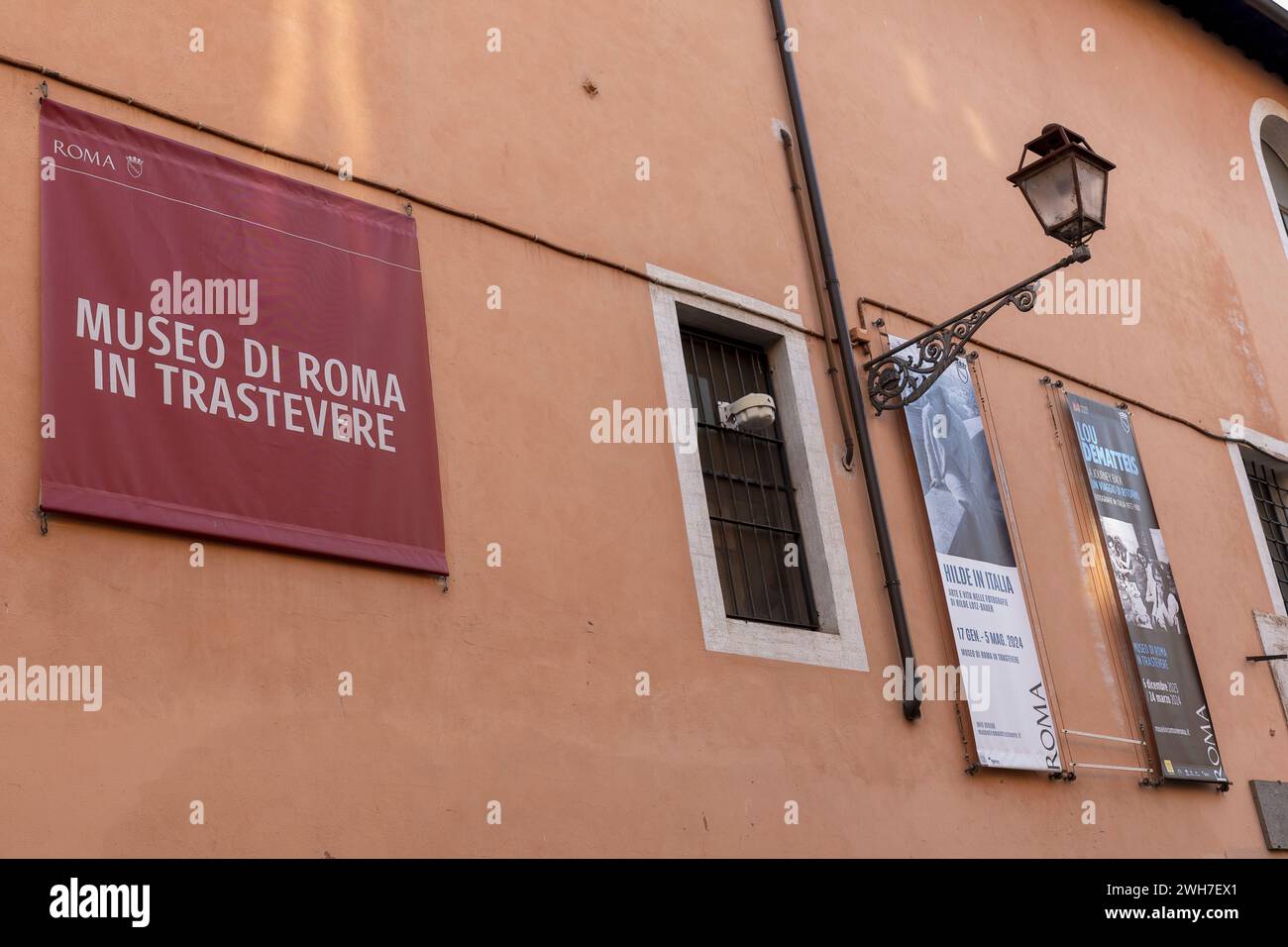 Museum of Rome in Trastevere, Außenansicht, Lampenpfosten, Bannerschilder der laufenden Ausstellungen. Piazza Sant'Egidio, Rom, Italien, Europa, Europäische Union, EU Stockfoto