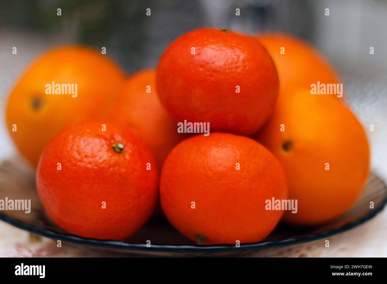 Reife Clémentine und Orangen auf einem Teller Stockfoto