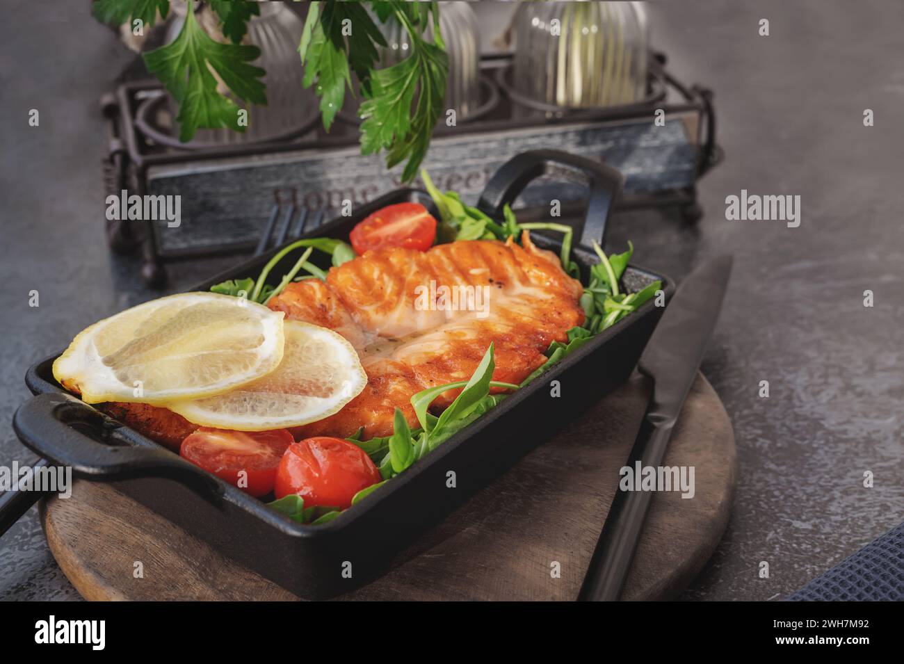 Gegrilltes Lachssteak mit Rucolasalat, Tomaten und Schalotten. Das Konzept der gesunden Ernährung, Ernährung, kalorienarm. Stockfoto