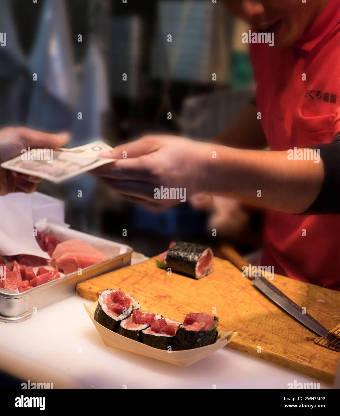 Nahaufnahme eines japanischen Marktkochs, der sein handgemachtes Thunfisch-Sushi verkauft Stockfoto