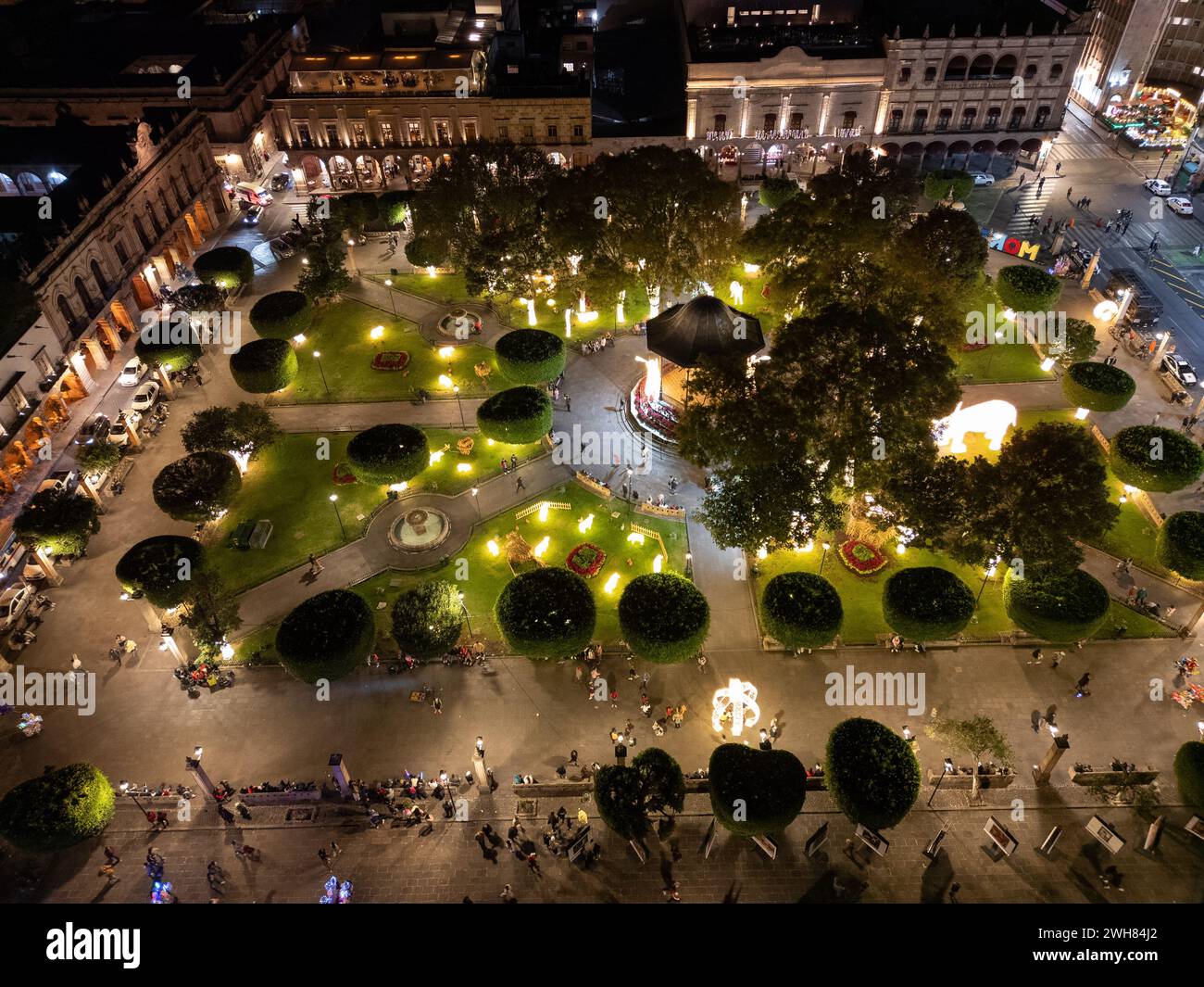 Nächtlicher Blick auf Morelias belebten Hauptplatz mit seinem zentralen Kiosk und Spaziergänger, beleuchtet von warmen Lichtern. Stockfoto