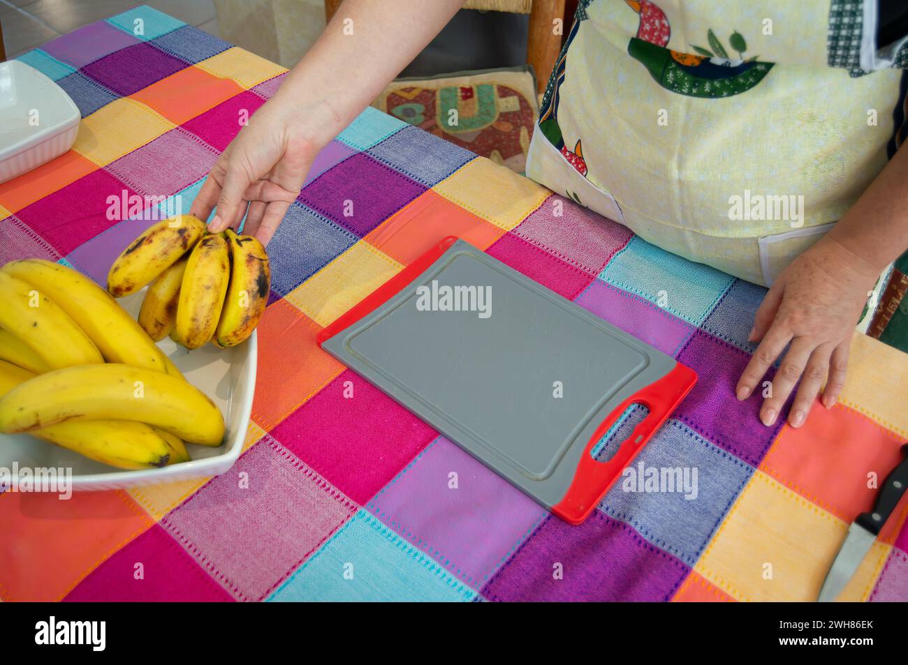 Handwerkliche Hände stellen Sie ein köstliches Bananengericht her, das Sie zufrieden stellen können Stockfoto