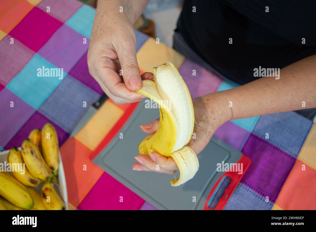 Handwerkliche Hände stellen Sie ein köstliches Bananengericht her, das Sie zufrieden stellen können Stockfoto