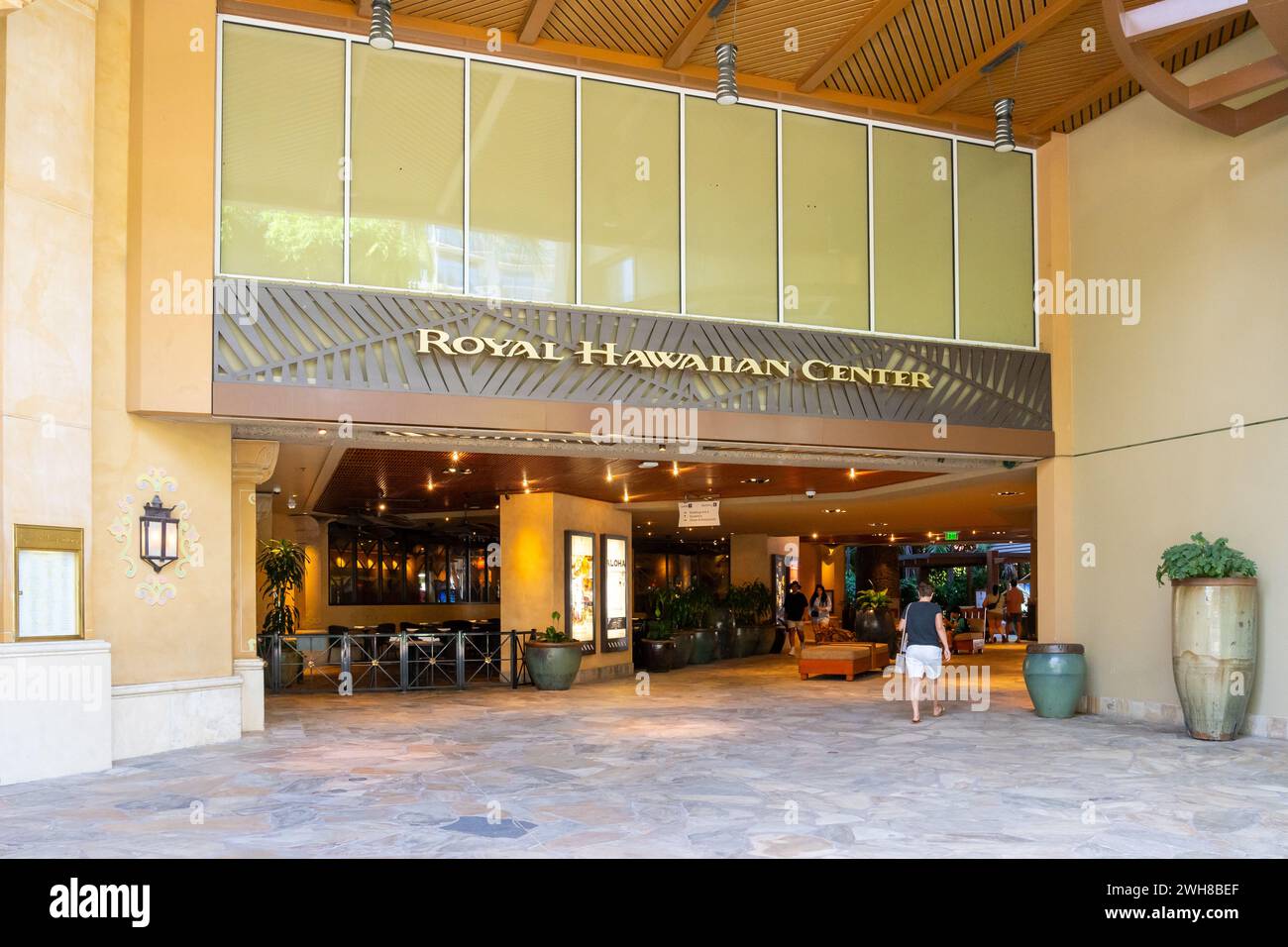 Eine Frau, die in das Royal Hawaiian Center in Waikiki, Hawaii, geht. Stockfoto