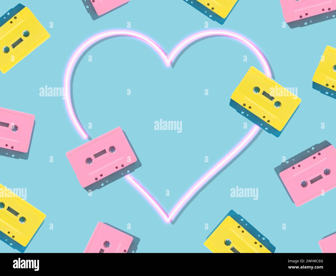 Muster von rosafarbenen und gelben Tonkassettenbändern im Retro-Stil mit rosa Neonherzen auf blauem Hintergrund. Kreatives Konzept der Retro-Technologie. Ästhetik der 80er Jahre. Stockfoto