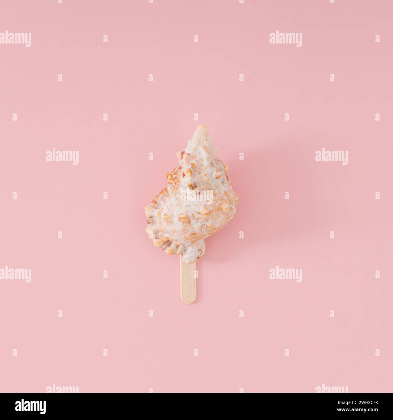 Trendiges Sommerlayout von Meeresschale mit Eisstock auf hellem pfirsichrosa Hintergrund. Minimales Sommerkonzept. Kreative Idee für Strandessen. Stockfoto