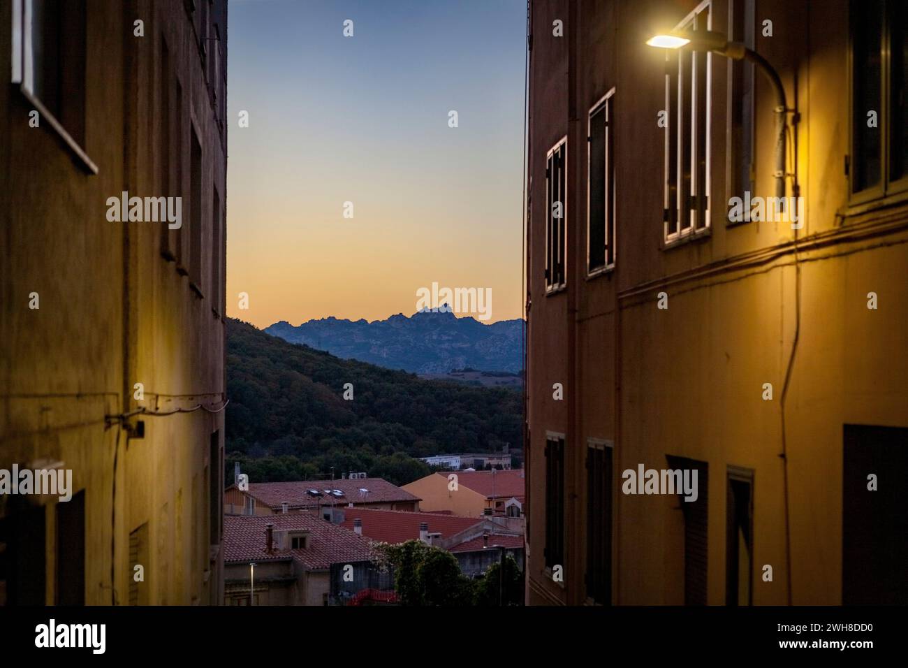 Blick auf eine enge Straße in Richtung Berge in der Abenddämmerung, Tempio Pausania, Sardinien Stockfoto