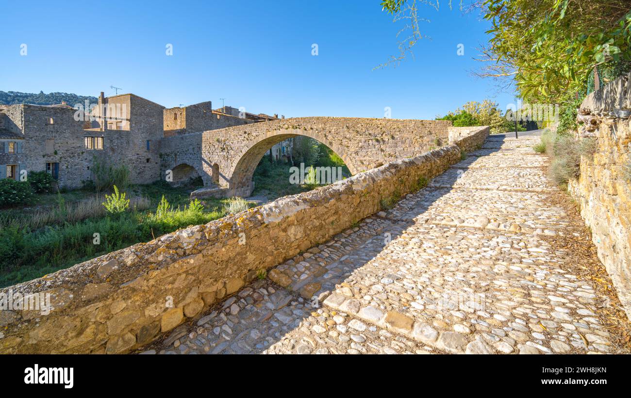 Die alte mittelalterliche Steinbrücke von Lagrasse, Frankreich, an einem sonnigen Frühlingsmorgen ohne Menschen aufgenommen. Stockfoto