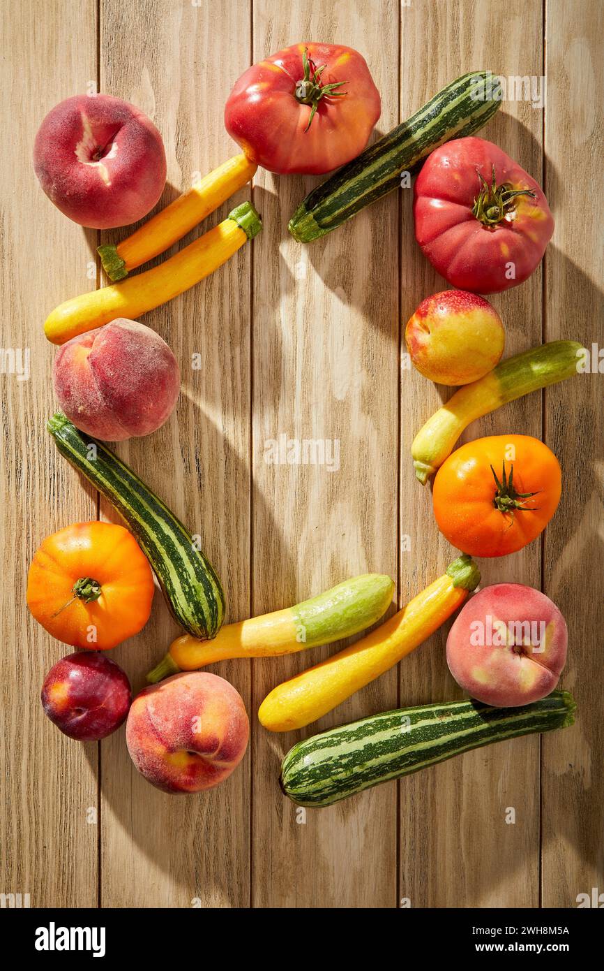 Tomaten, Zucchini und Steinobst auf Holzhintergrund Stockfoto