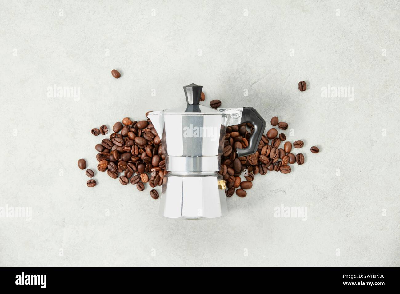 Flache Lage der Mokakanne Kaffeemaschine und Kaffeebohnen auf grauem Steinhintergrund Stockfoto