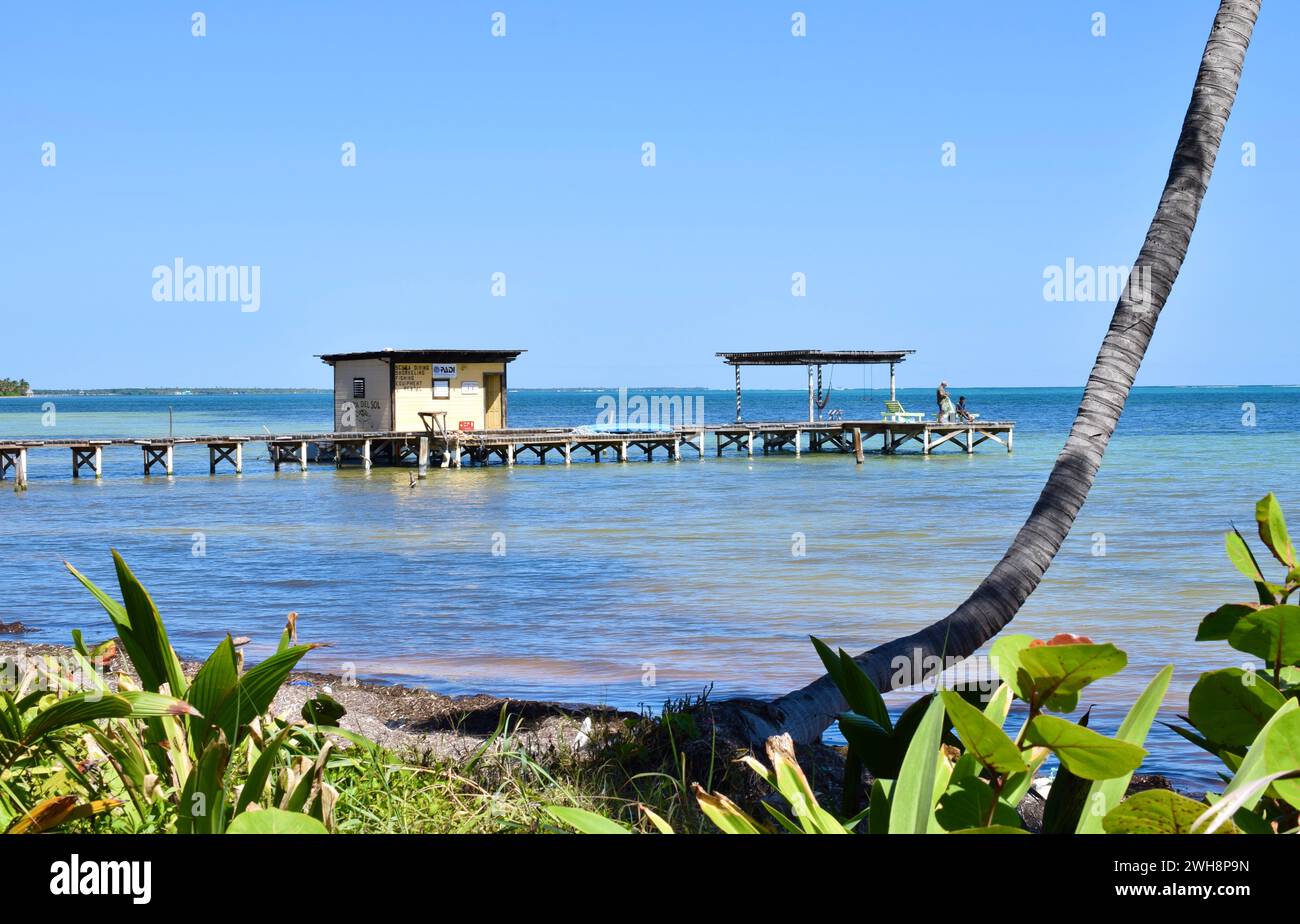 Zwei Leute an einem Pier an einem ruhigen, klaren Tag im Norden von Ambergris Caye, Belize, Mittelamerika. Stockfoto